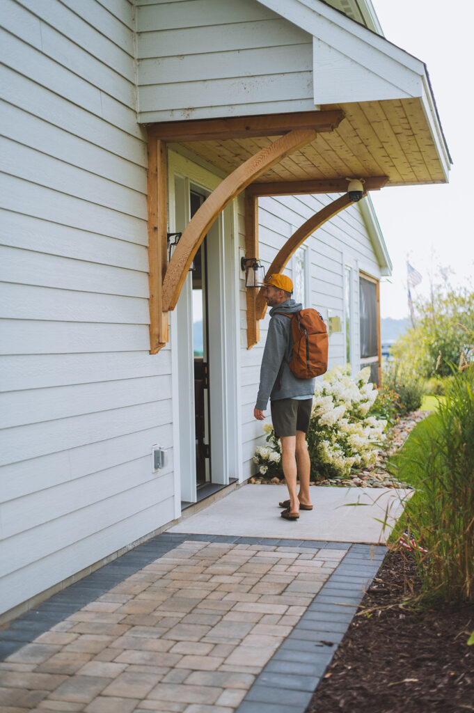 Man with a backpack heading to open the door of his Brainerd Lakes cabin rental.