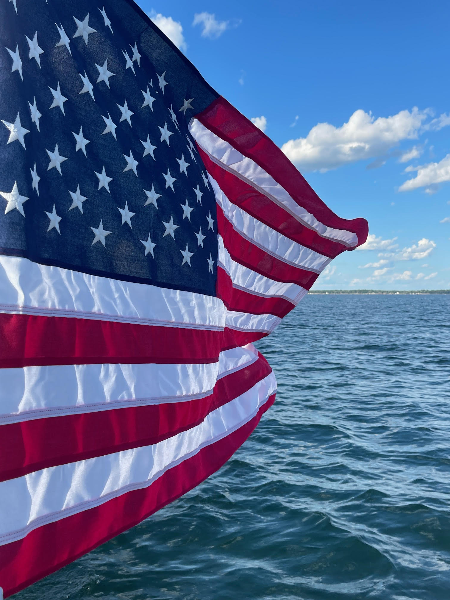 American Flag flying over water