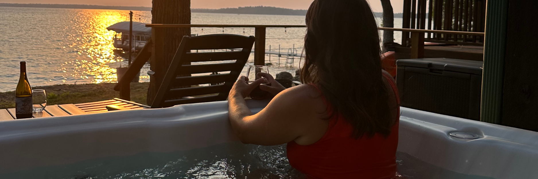 View of the lake from the hot tub with a glass of wine.